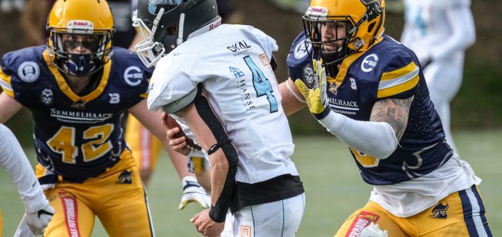 der balltragende Footballspieler wird von zwei Verteidigern angegriffen