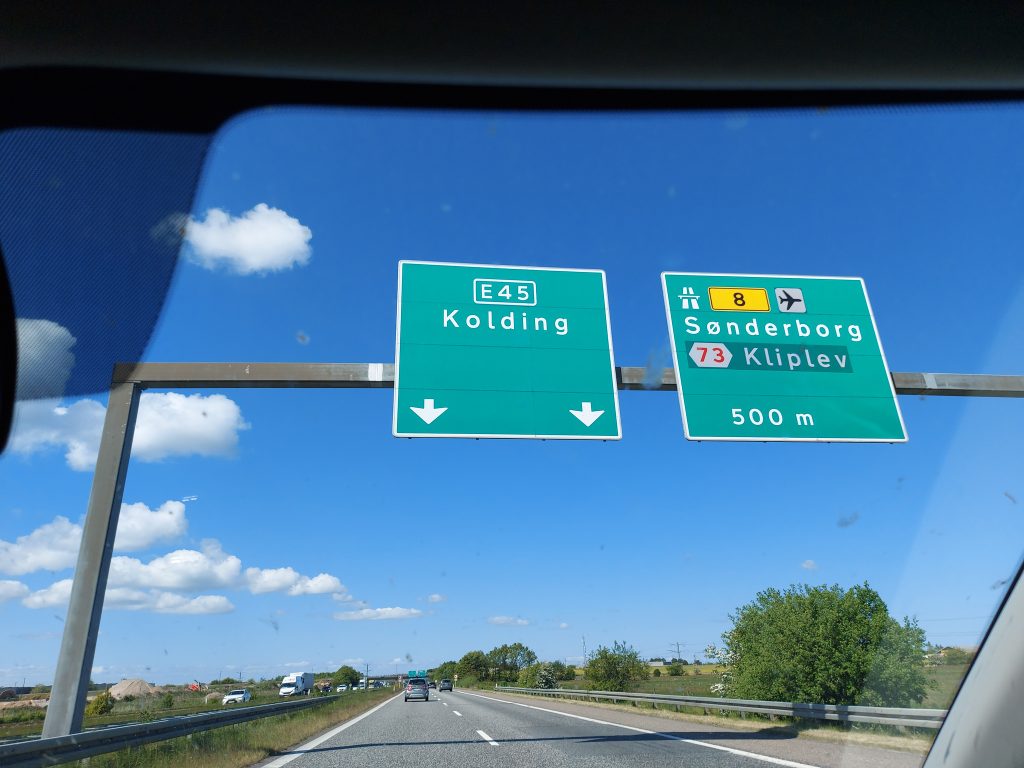 Wegweiser auf einer dänischen Autobahn. Geradeaus geht es weiter auf der E45 nach Kolding, rechts ab nach Sønderborg.